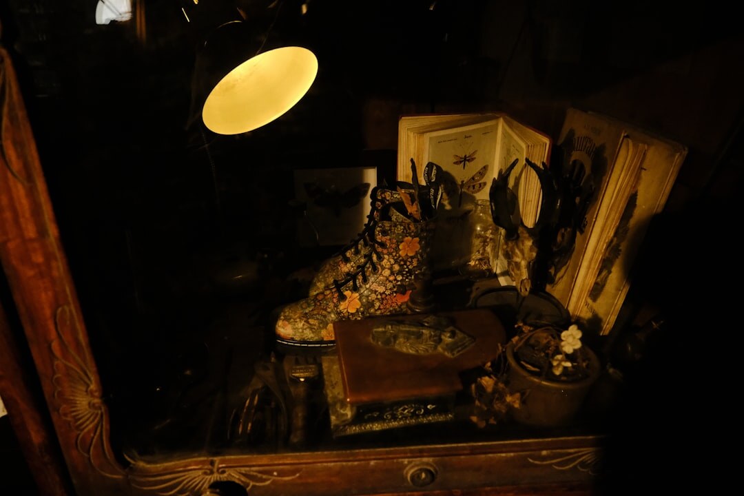 Moody writer's desk with a typewriter, notebook and magnifying glass lit by lamplight